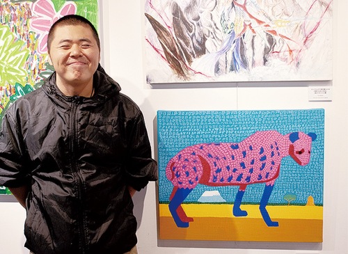 ポスターに使用された「ハイエナの女王」と作家の奥津大希さん