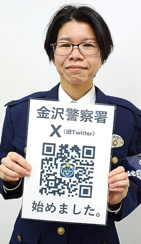 アカウントのフォローを呼び掛ける署員。写真内の二次元コードで検索できます