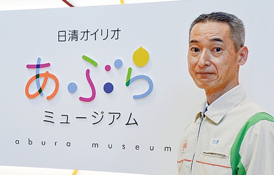 油脂の黄色、磯子の海や船の青・水色などの色が入った｢あぶらミュージアム｣のロゴと川邊事業場長