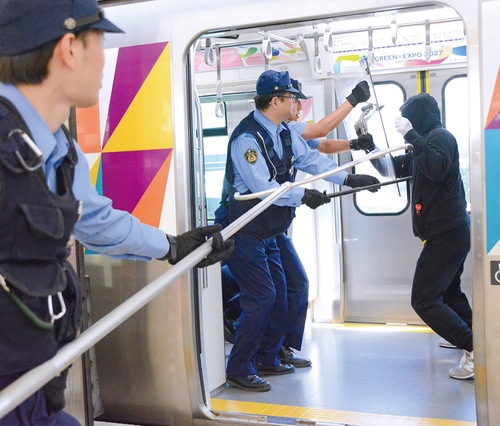 列車内で刃物を持った不審者に対応する警察官