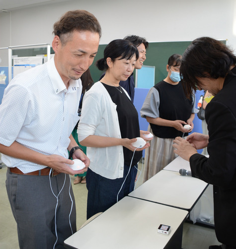 装置を身に付けて生理痛を体験する参加者