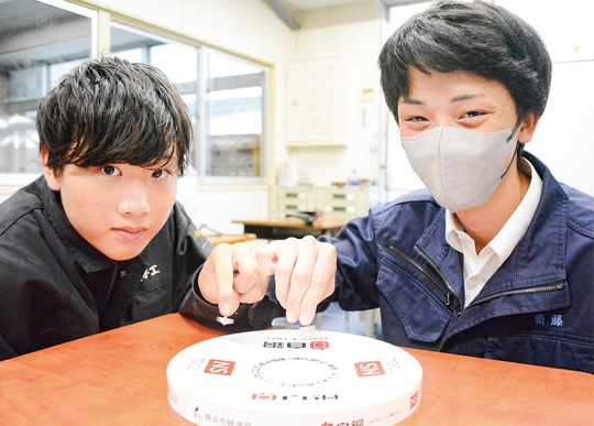 自作のコマを手にする遠藤さん（左）と齋藤さん