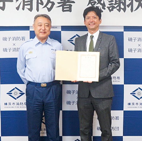 感謝状を手にする三川さん（右）と渡邉署長＝磯子消防署提供