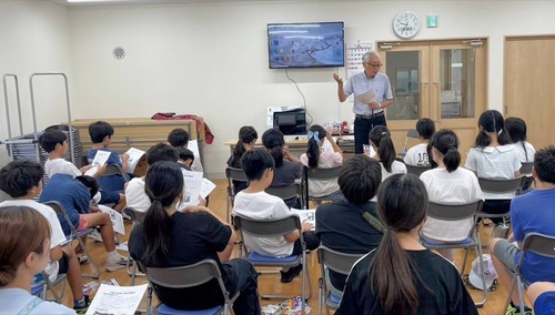 自治会館で話を聞いた児童たち＝中原自治会提供