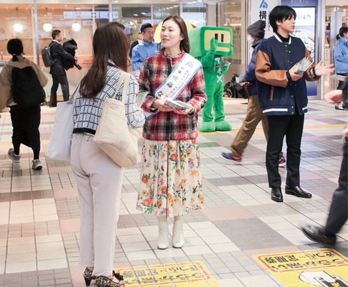 チラシを配る佐藤さん