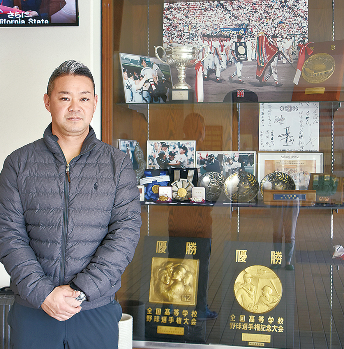 校舎入口に並ぶメダルや楯など栄光の数々と平田監督