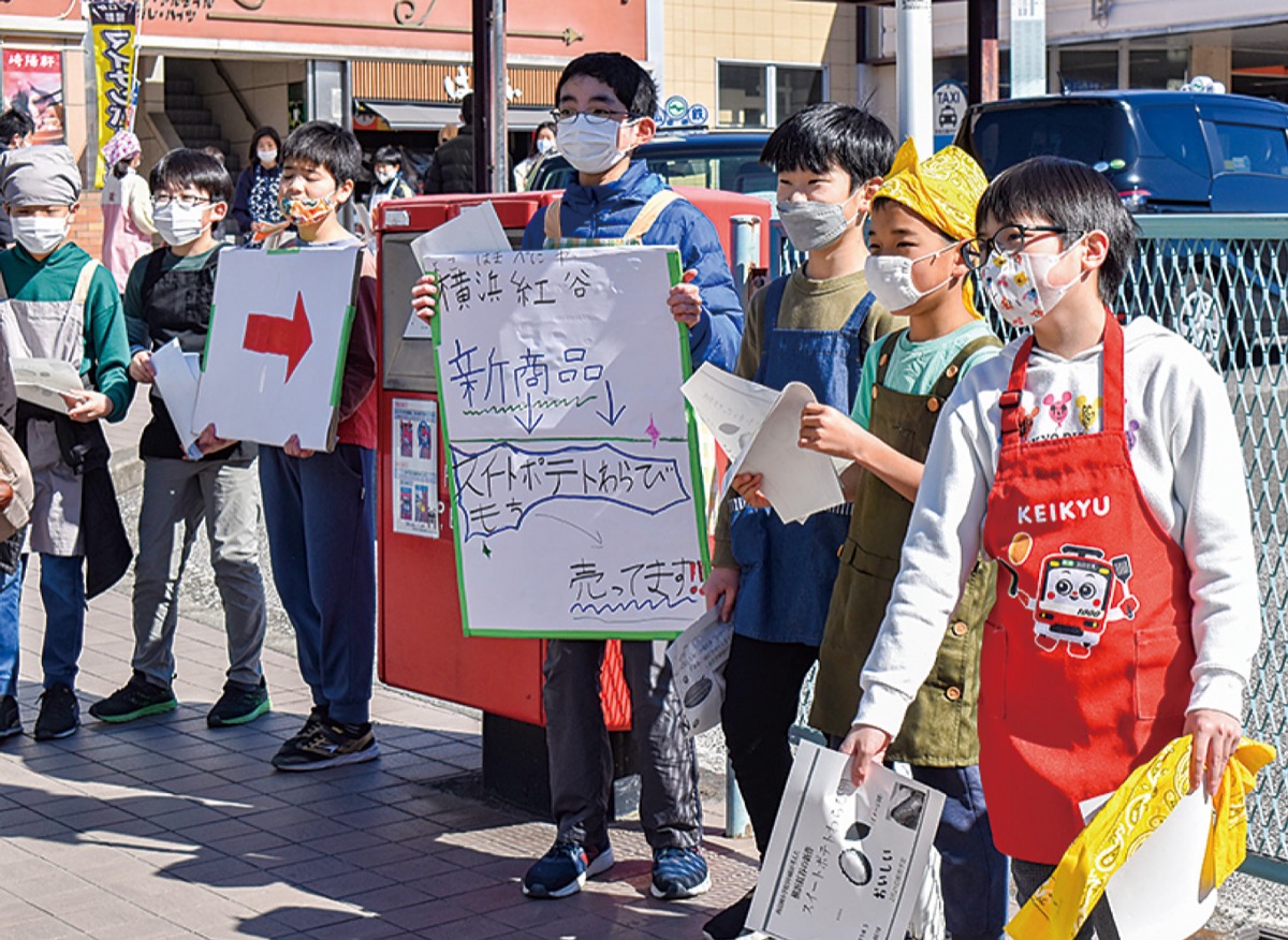 駅前でチラシを配る児童