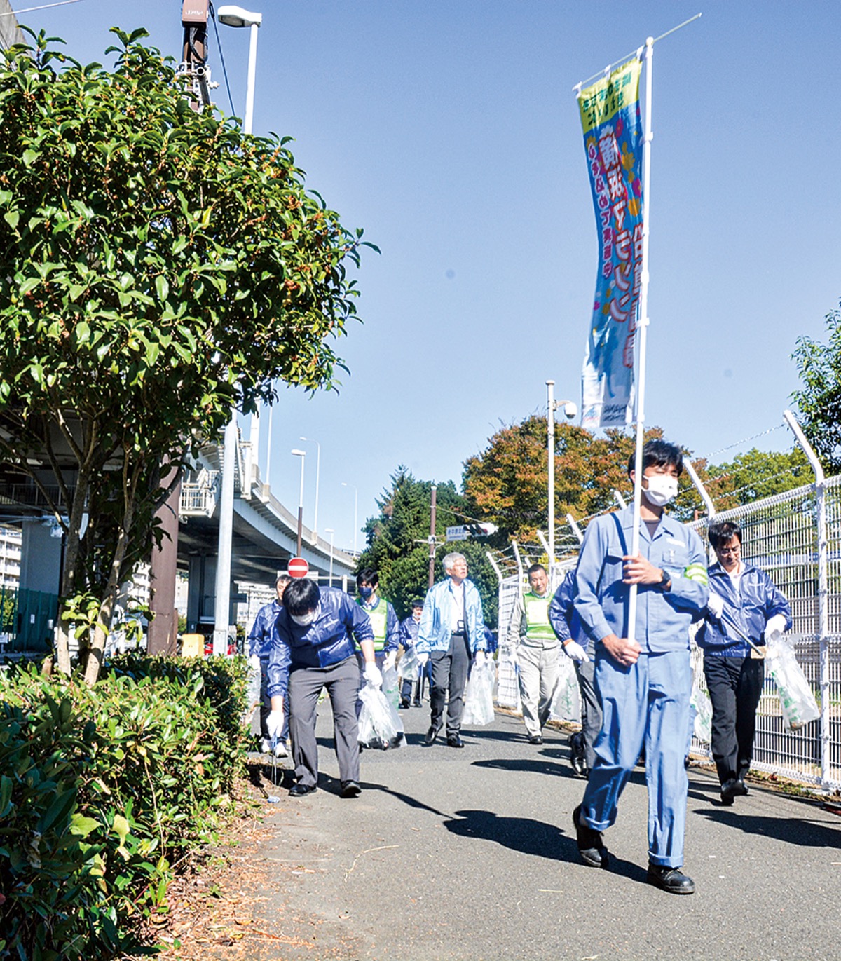 歩きながらごみを拾う参加者たち