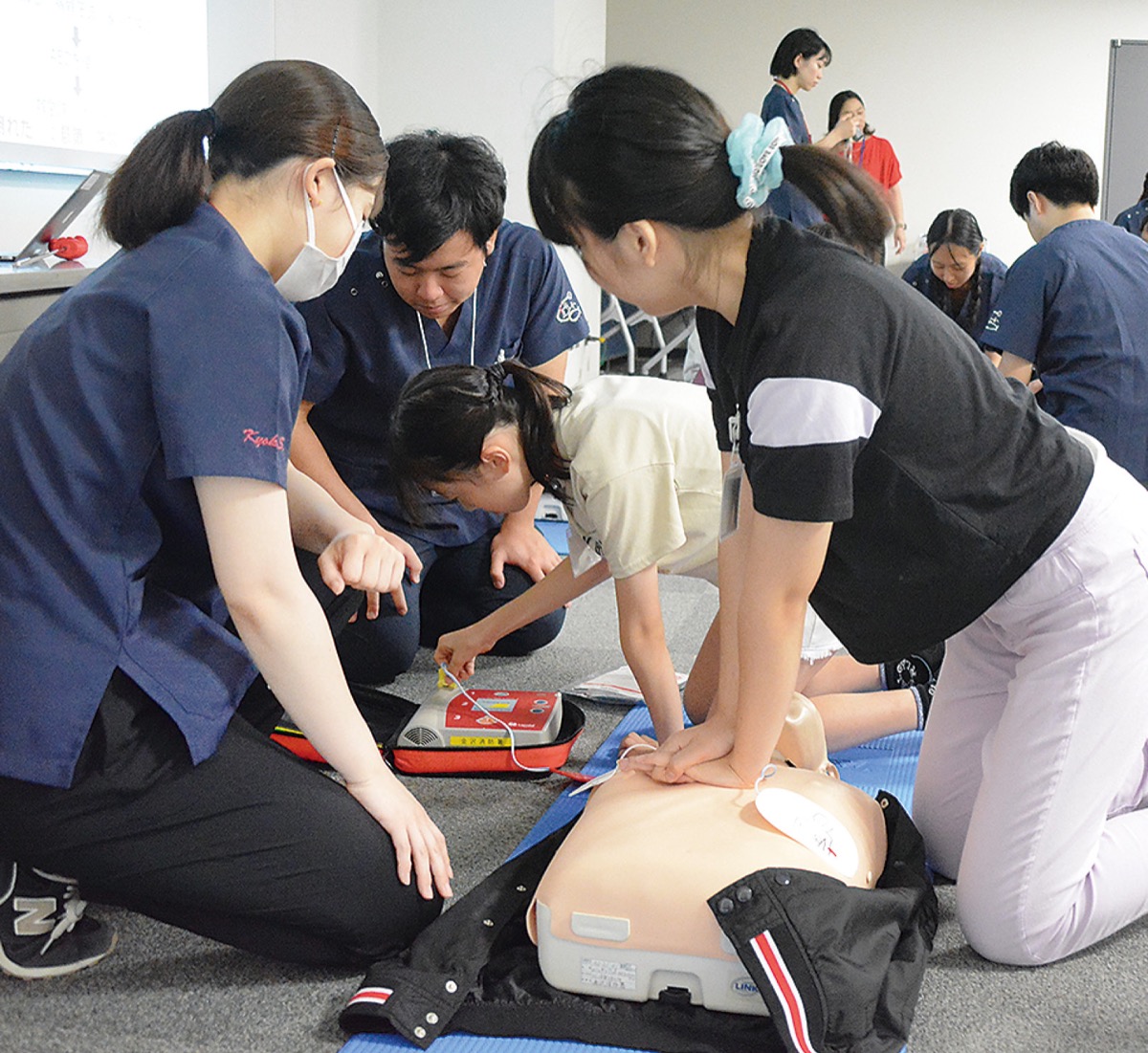 胸骨圧迫やAEDの使い方を体験する参加者たち