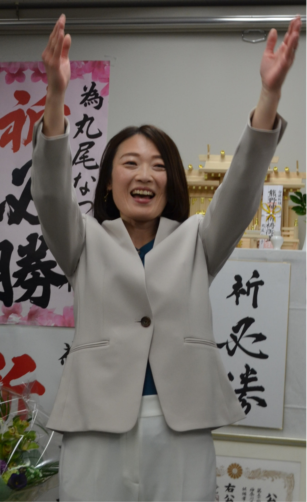 万歳をする丸尾氏＝2月8日