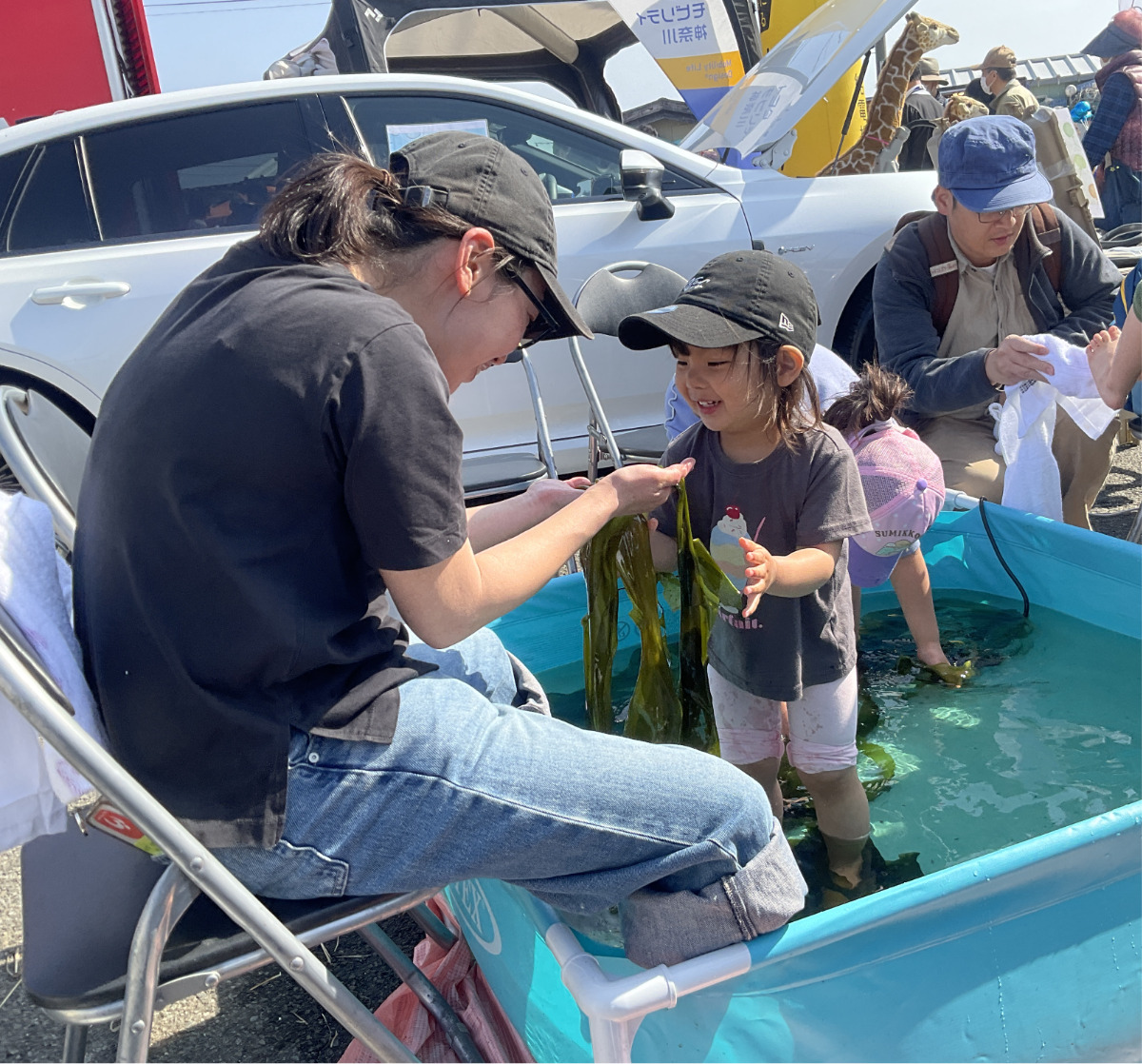 SDGsブースのコンブの足湯を楽しむ親子