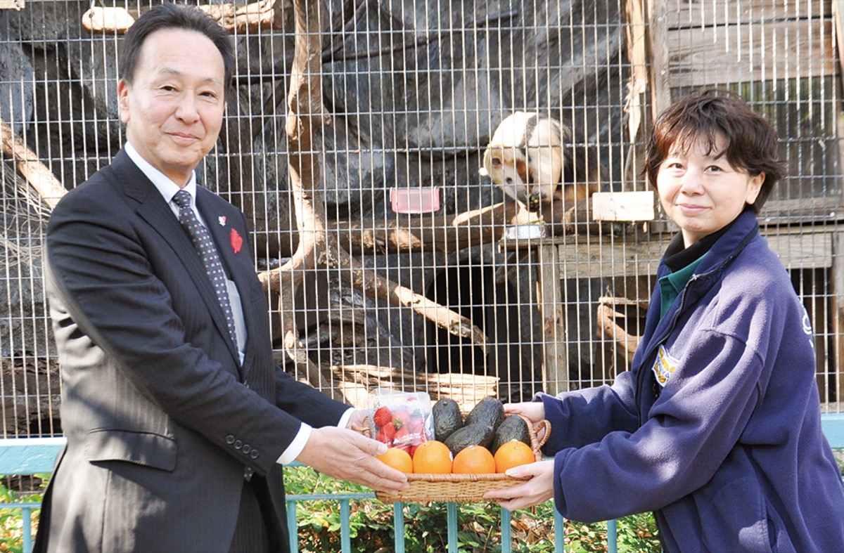 プレゼントの果物を手渡す中島常務理事（左）と田村園長