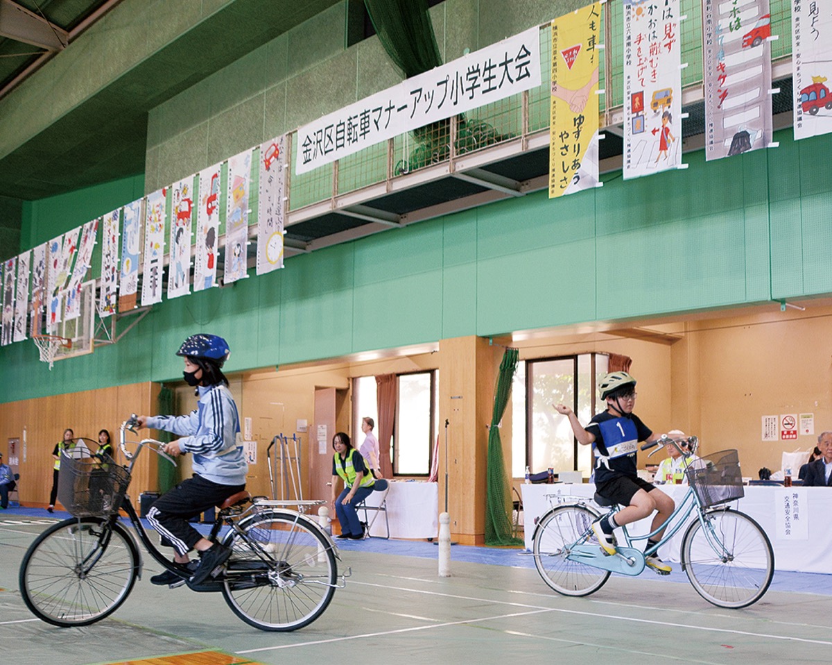 体育室で自転車に乗る児童たち