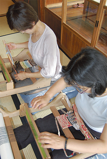 卓上織機でコースターを作る参加者たち
