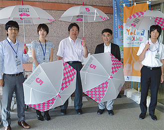 傘を手にする山本代表（中央）と坂本区長（右から２番目）、区職員たち