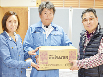 阿部会長（右）に水を手渡す、谷口敦、谷口実穂両代表取締役