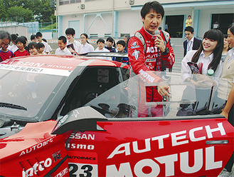 レーシングカーの周りで子どもたちに講義を行う松田選手