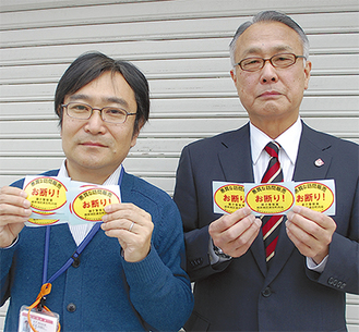 ステッカーを手にする横田会長（右）と根岸地域ケアプラザの担当者
