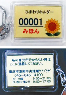 表面（写真上）にはひまわりのイラストに登録番号が記され、裏面に連絡先が記されている。