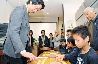 子どもたちと将棋を指す瀬川さん（左）