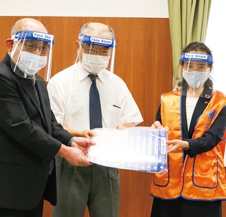 （左から）フェイスシールドを受け取る田川会長、池袋会長と横浜港南ライオンズクラブの松本さん