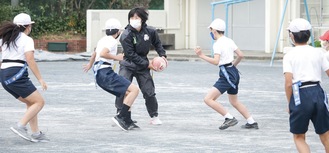 児童と一緒にプレーする鈴木さん（中央）