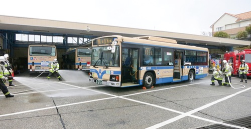 バスに放水する隊員＝同署提供