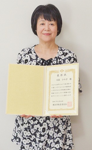 表彰状を持つ大泉さん