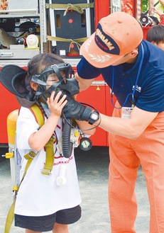 空気呼吸器体験をする子ども（左）