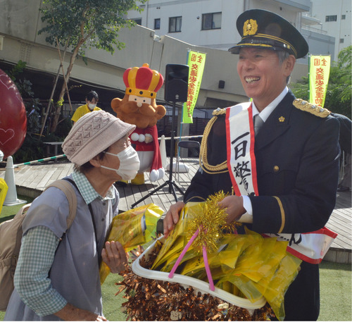 啓発物を配るパンチさん