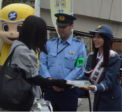 啓発グッズを配る山本さん