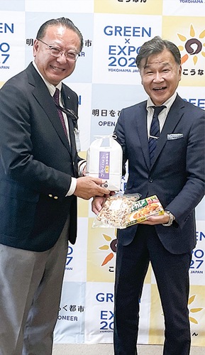 寄附された物品を持つ栗原区長（左）と金子取締役社長
