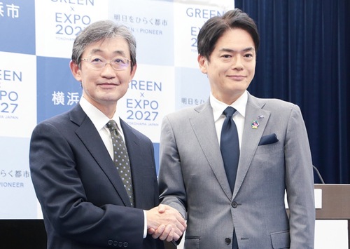 会見で握手するＡＧＣの吉羽執行役員（左）と山中市長