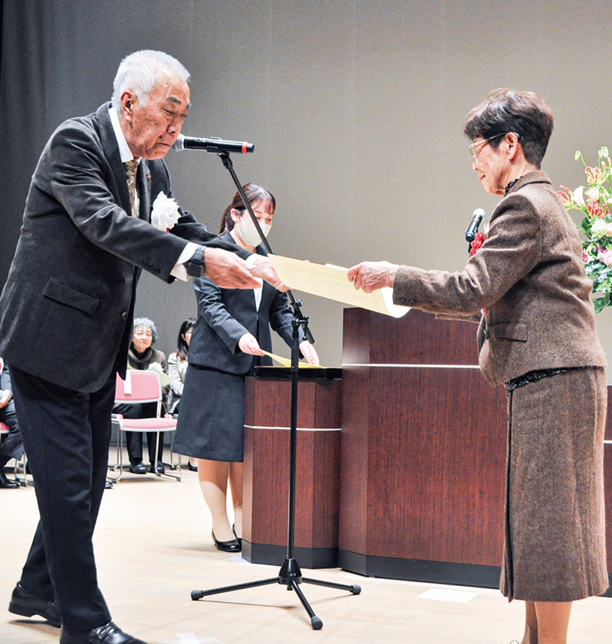 受賞者へ表彰状を手渡す荻久保会長(左)