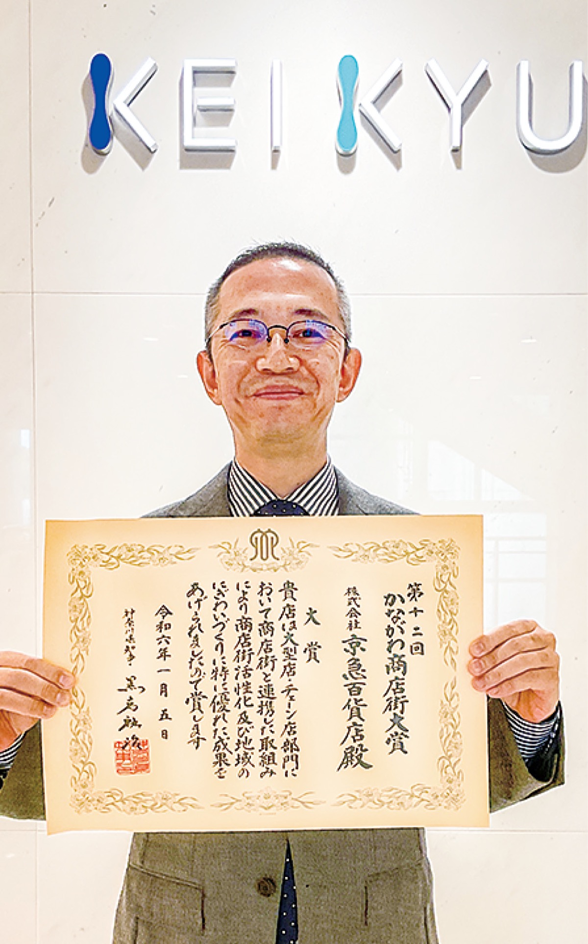 表彰状を手にする角能総務部長