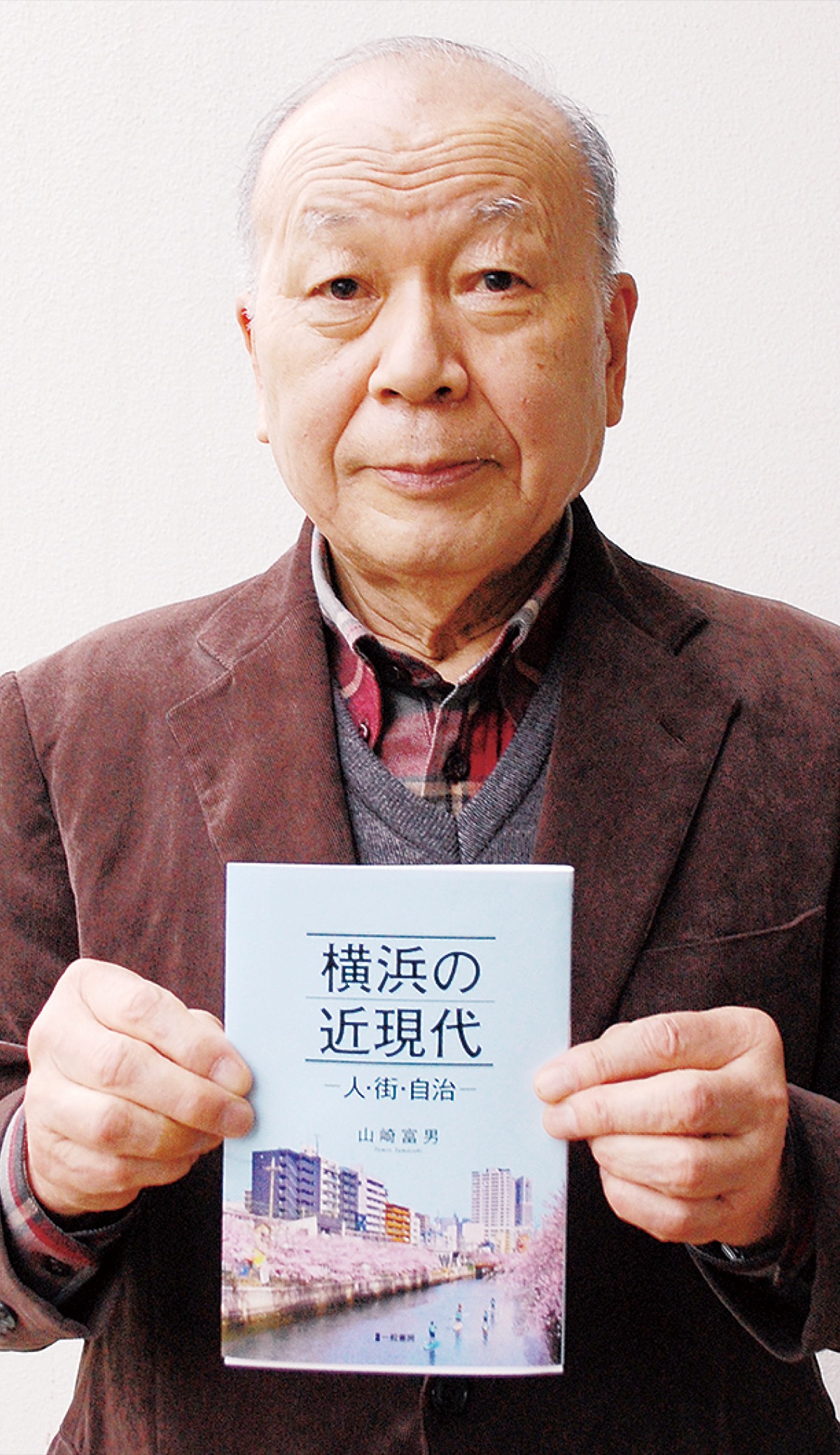 『横浜の近現代』を手にする山崎さん