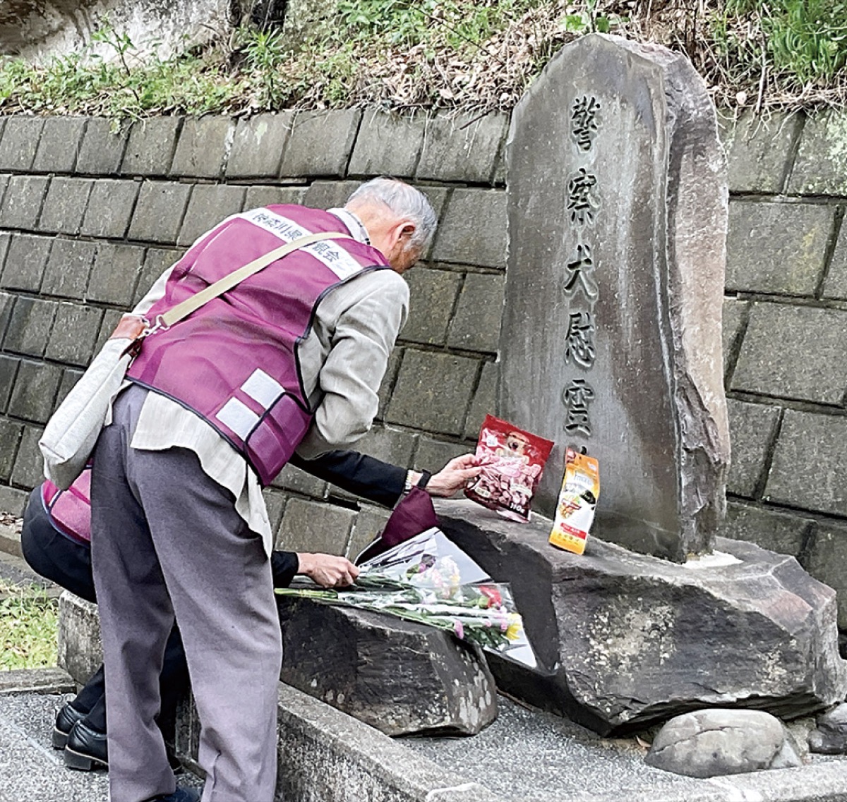 慰霊碑に花を供えた会員