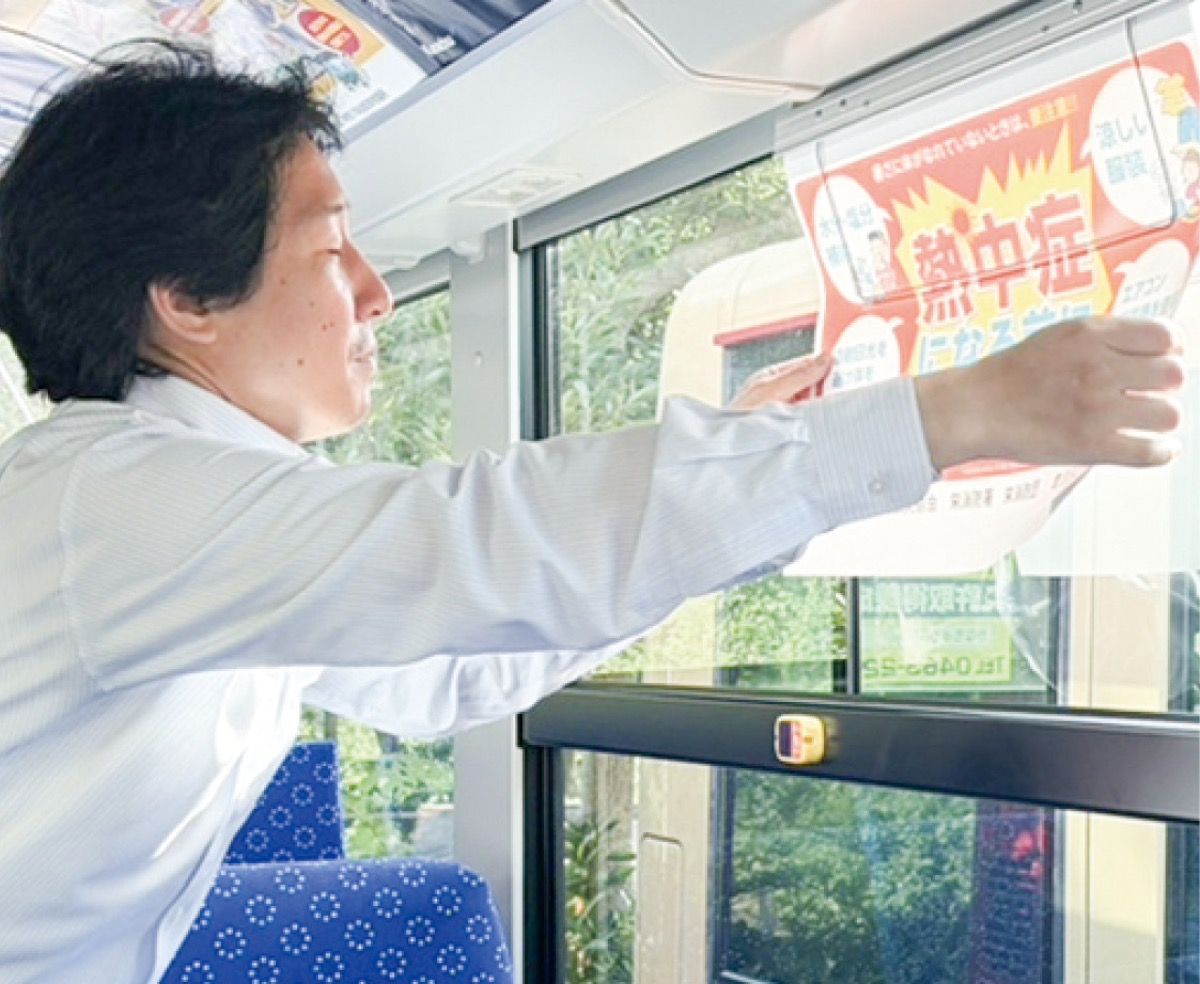 ポスターを設置する神奈中(株)の社員