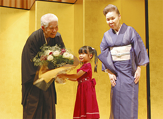 孫から花束を受け取る鶴田さん（左）