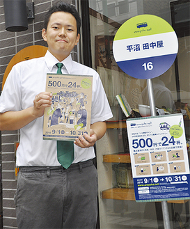 実行委員会代表の鈴木さん。参加各店舗にはバス停に模した目印がある