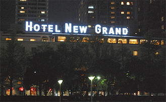 ネオンの白い文字が浮かび上がるホテルニューグランド本館（山下公園より撮影）