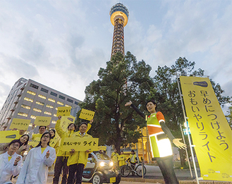 黄色に点灯したマリンタワー前で。白衣を着て計測するなどユニークな演出で、ドライバーだけでなく歩行者の関心も集めていた
