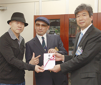横山さん（中央）とサイモンさん（左）が市民局で目録贈呈