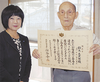 大久保区長から祝状を受け取った鈴木さん（写真右）