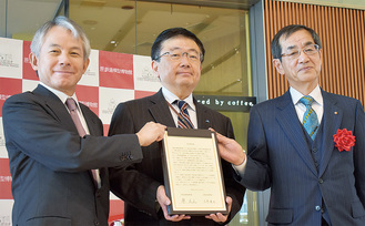 協定書を手にする原副館長（左）と京都鉄博の三浦館長。中央はＪＲ西日本の二階堂副社長