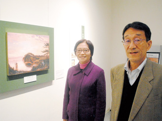 岩田の姪にあたる理事長の武田春子さん（左）と、夫で館長の由隆さん。作品はチャールズ・ワーグマン「海岸風景」