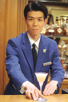 東京都知事賞のブルージャケットを着てカクテルを提供する鮎川さん