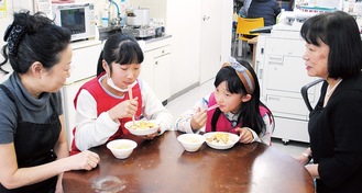 ちらし寿司を頬張る子ども（左は長島さん、右が竹川さん）