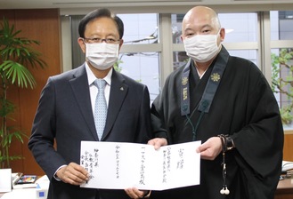 目録を手にする（左から）県医師会の菊岡会長、県仏教青年会の西郊会長