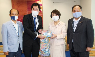マスクを手渡す坂倉理事長（中央左）